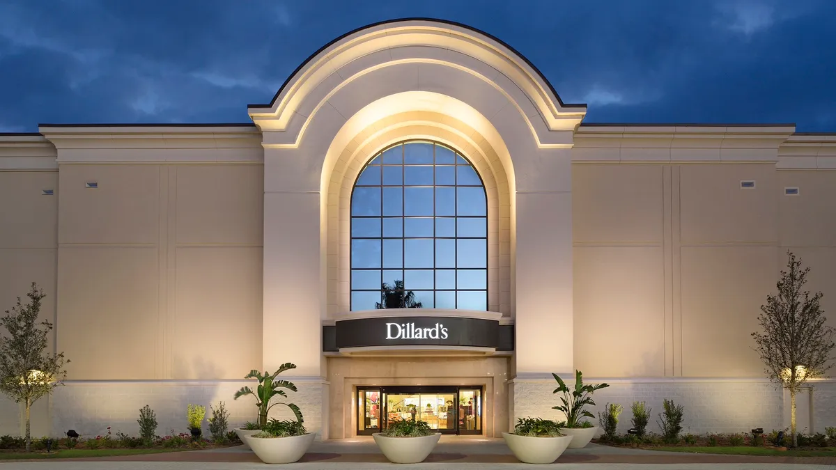 A grand department store entrance beneath a dark blue sky.