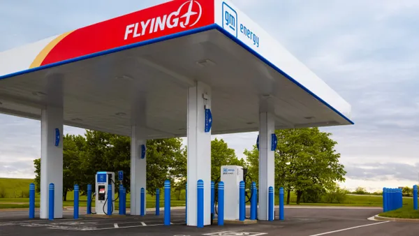 An electric vehicle charging station co-branded by Flying J and GM Energy with the two company logos visible on the overhead canopy