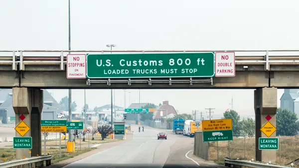 A green sign indicates a U.S. Customs area is 800 feet away and reads "Loaded trucks must stop."