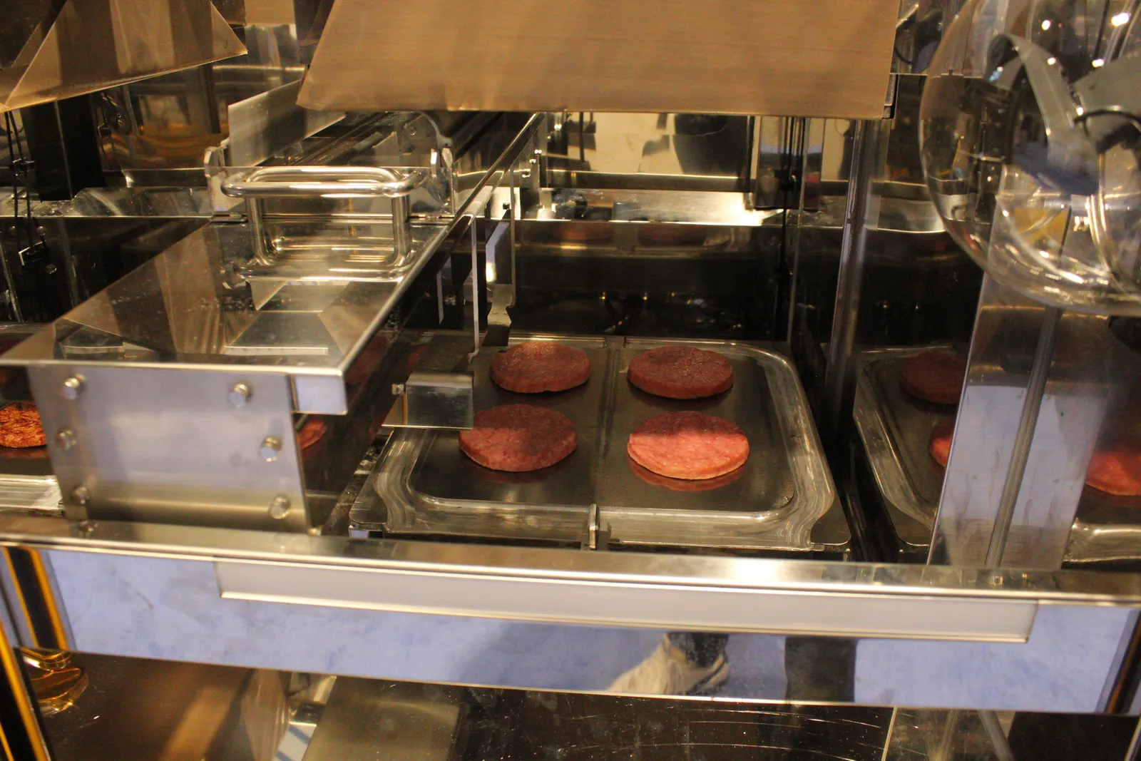 A look at four simulated patties inside Aniai's AI powered robot grill.