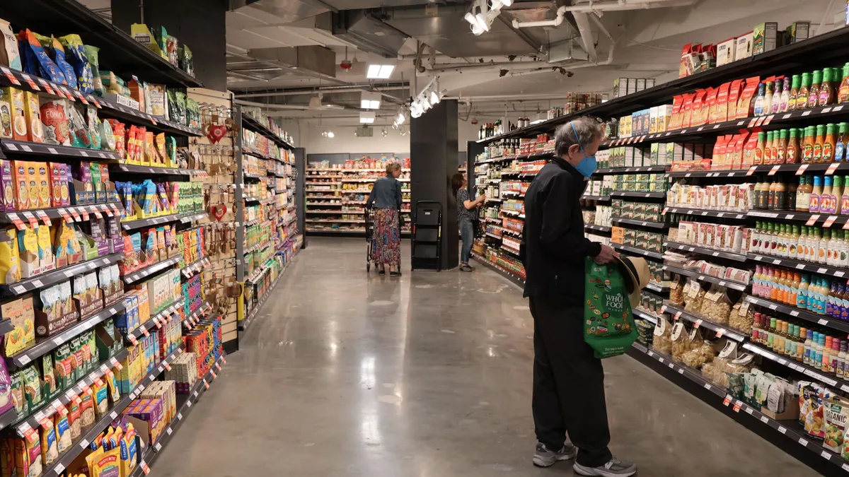 Grocery store aisle with two people shopping