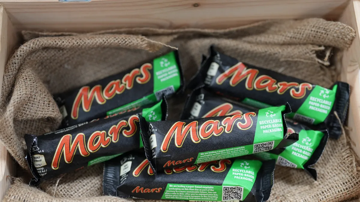 A Mars bar candy bar with a paper wrapper.