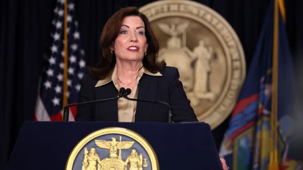 New York Gov. Kathy Hochul speaks from a podium featuring the seal of New York.