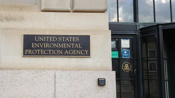 The U.S. Environmental Protection Agency sign on a tan building and glass double-doors on the right side.