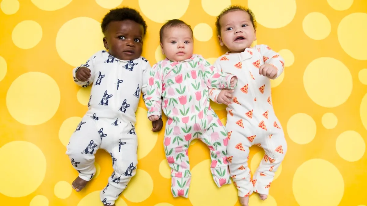 Three babies in Monica + Andy onesies on a yellow background.