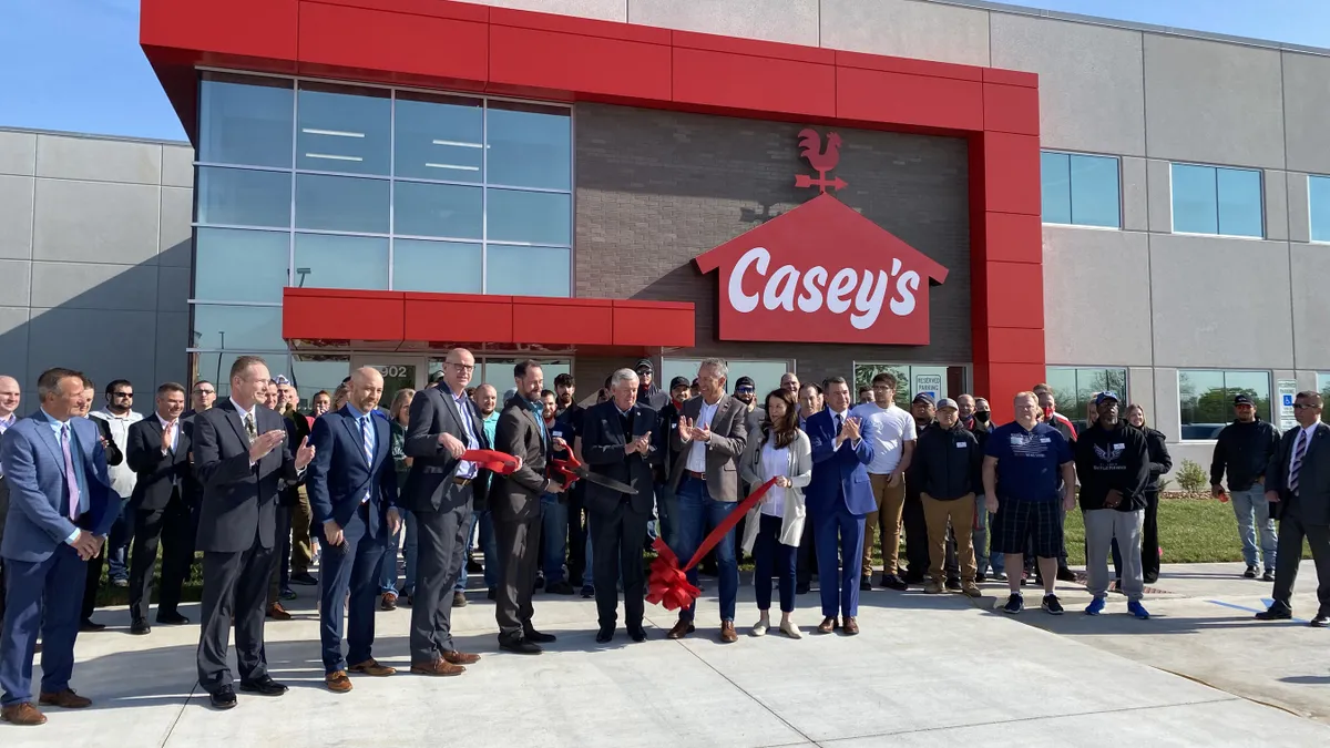 Casey's General Store executives, Missouri Gov. Mike Parson and local leaders participate in a ribbon cutting ceremony in front of the company's Joplin, Missouri, distribution center in 2021.