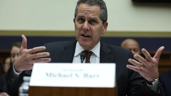 Michael Barr, Federal Reserve Board official, speaks during a Congressional hearing as other people sit behind him.