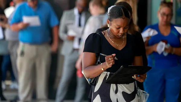 People line up as they wait for a job fair to open.