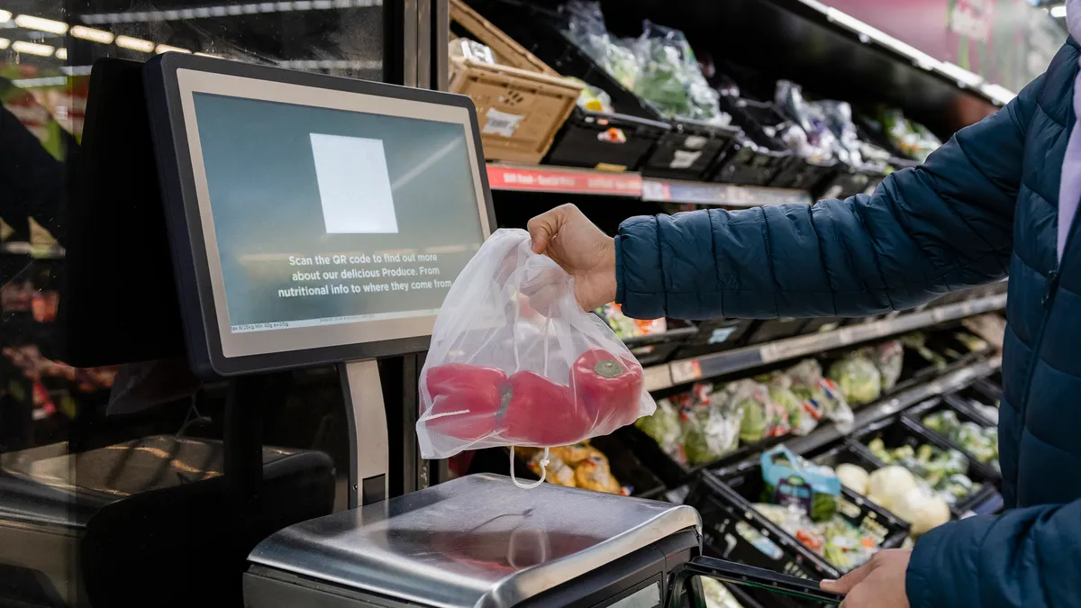 Customer buying red bell peppers at a self-checkout station