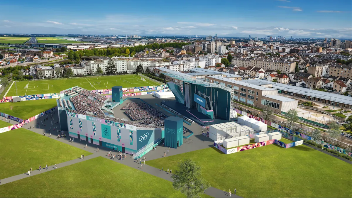 An aerial view of a climbing wall and stands in an urban park.