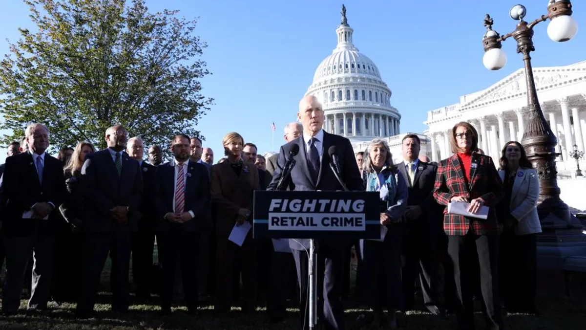 A group of people in suits standing behind a sign that reads "Fighting retail crime." The U.S. Capitol is in the background.