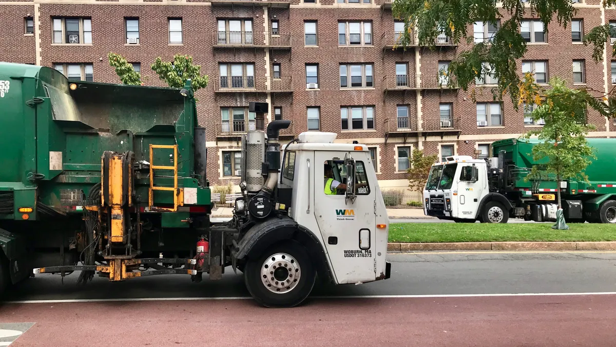 Waste Management trucks passing each other in Somerville, Massachusetts