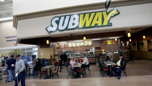 A photograph of a restaurant with Subway signage that is inside a Walmart