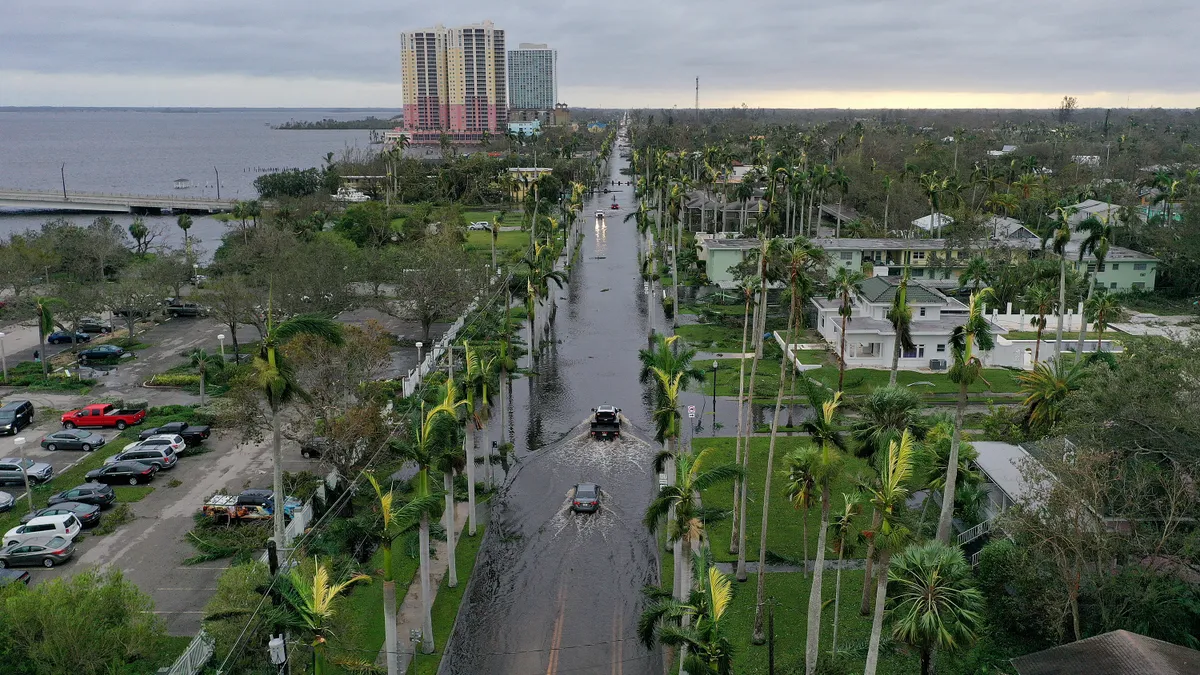 In this aerial view, vehicles make their way through a flooded area after Hurricane Ian passed through the area on September 29, 2022 in Fort Myers, Florida.