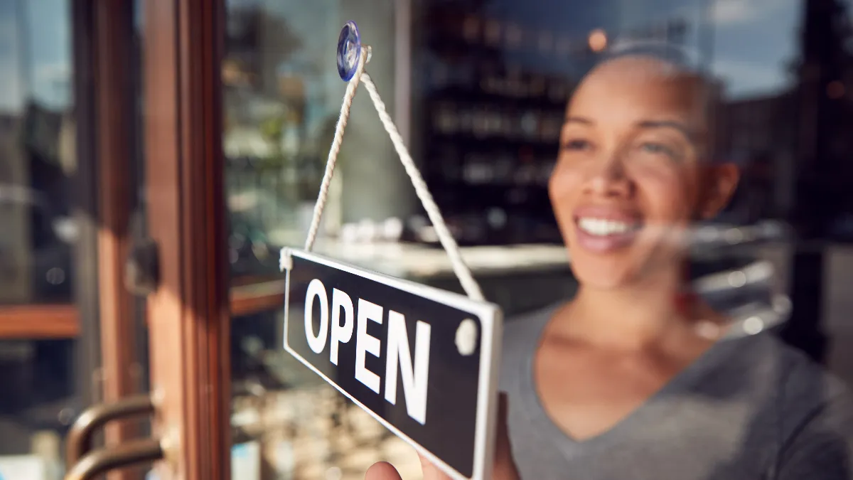 An image of a woman at open sign.