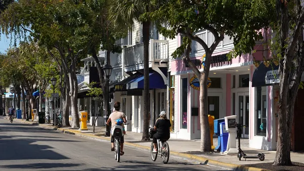 Bicyclists ride along street in Key West, Florida