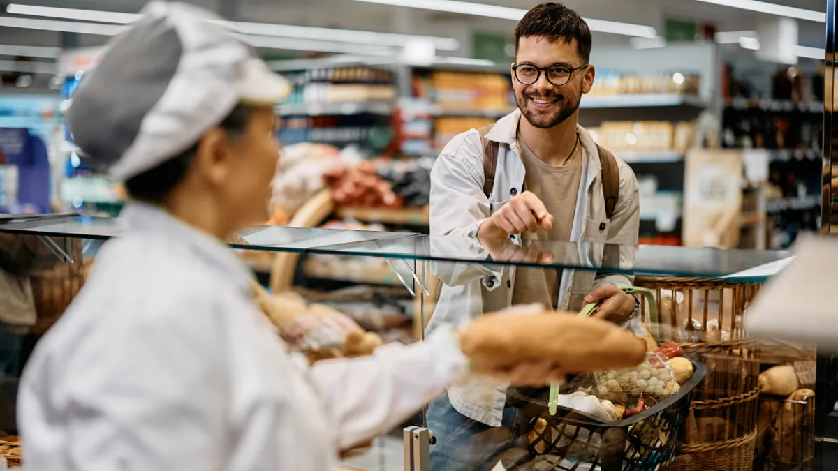 Person buying bread in supermarket bakery