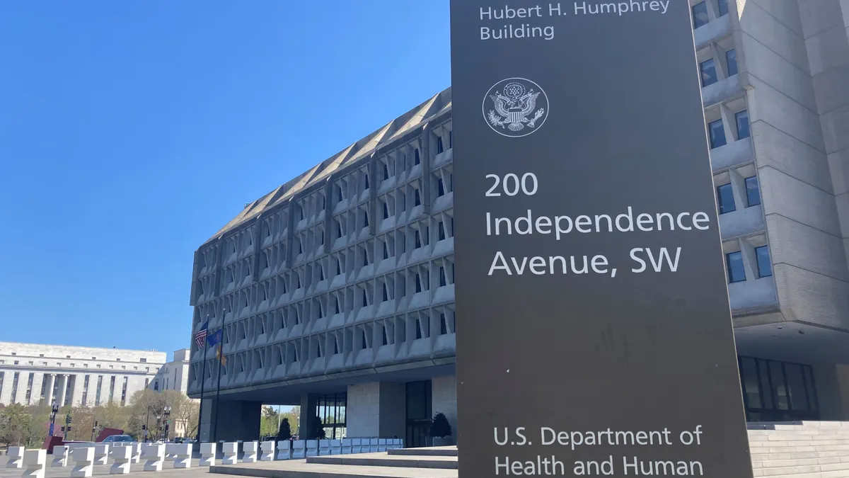 A sign for the U.S. Department of Health and Human Services stands outside a concrete building.