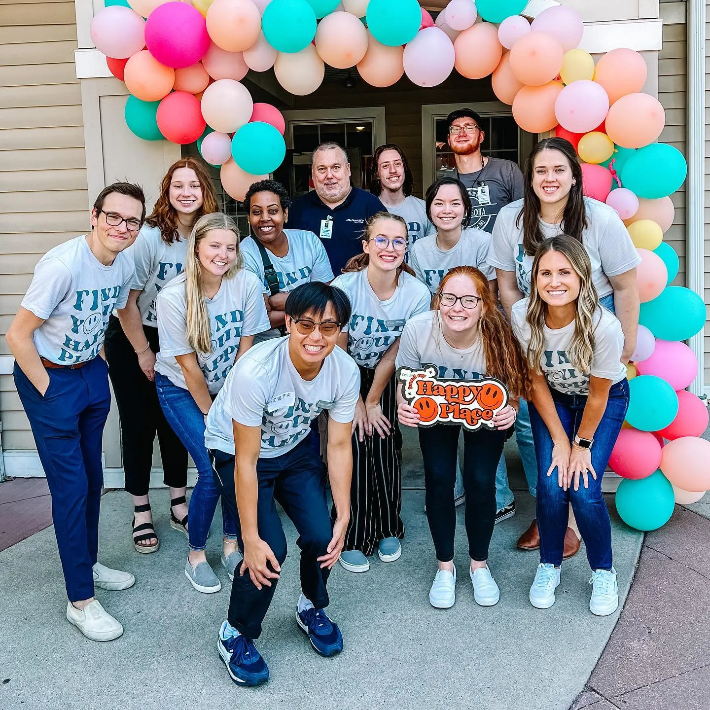 A group of people standing under balloons