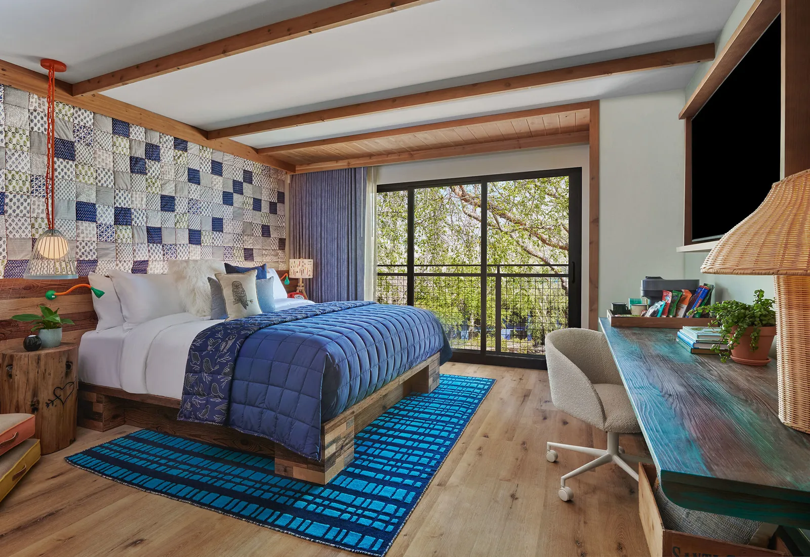 A blue bed in a hotel room.