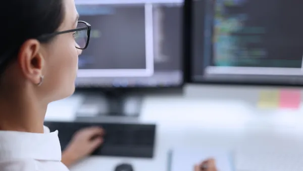 a tech worker looks at a monitor