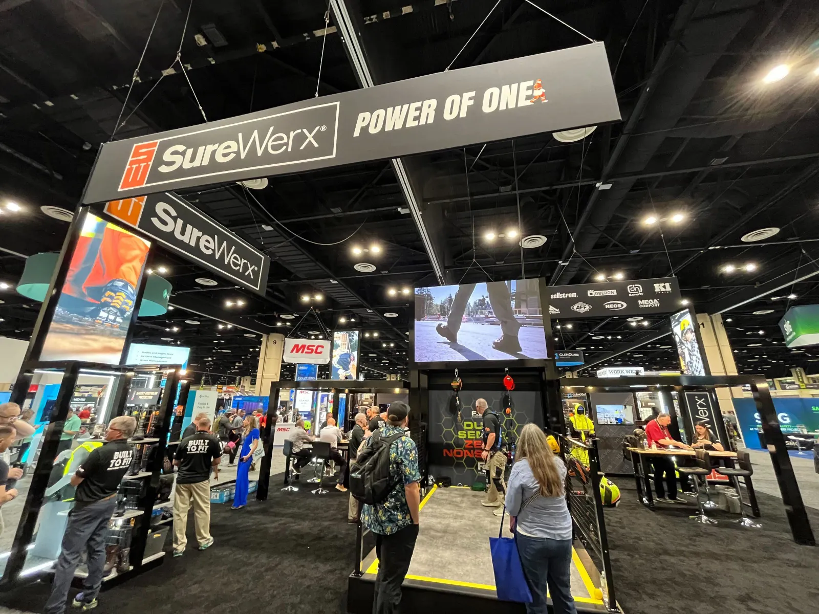 An expo hall booth displays fall safety harnesses.