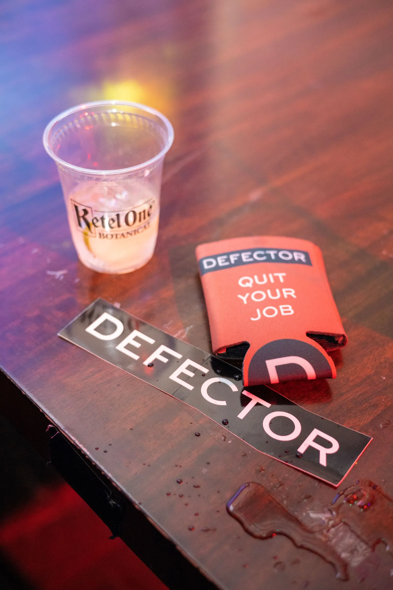Defector Media branded merchandise sits on a pub table