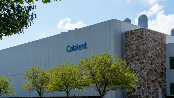 A sign reading Catalent hangs on the side of a factory building.