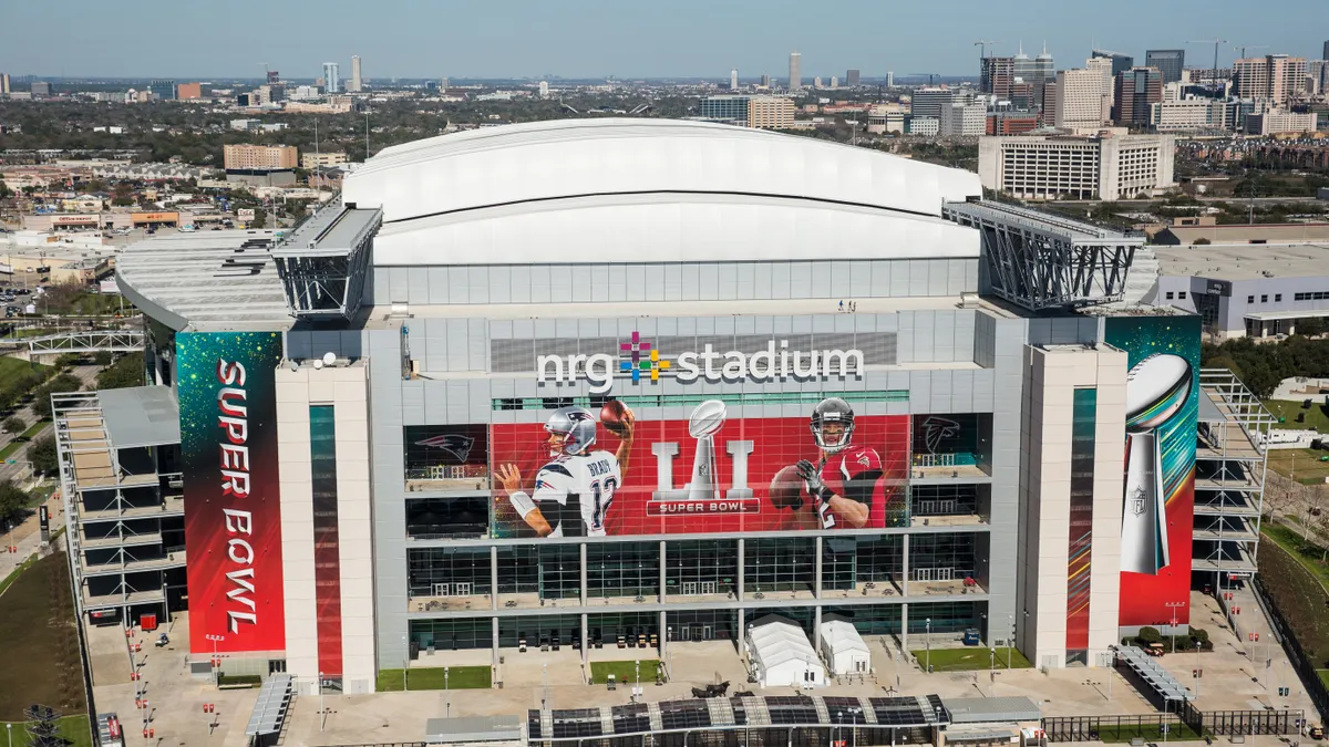 The exterior of NRG Stadium with large Super Bowl banners on the facade.