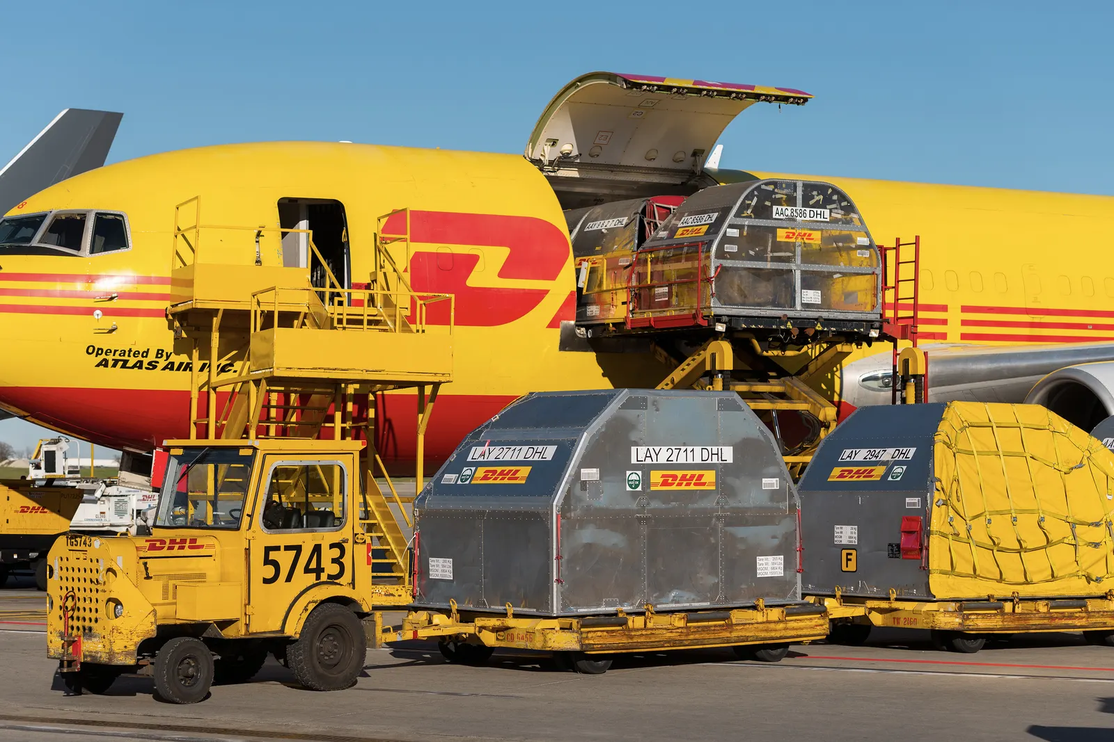 Plane at the DHL Hub in Cincinnati with ULDs on the tarmac being loaded into the aircraft