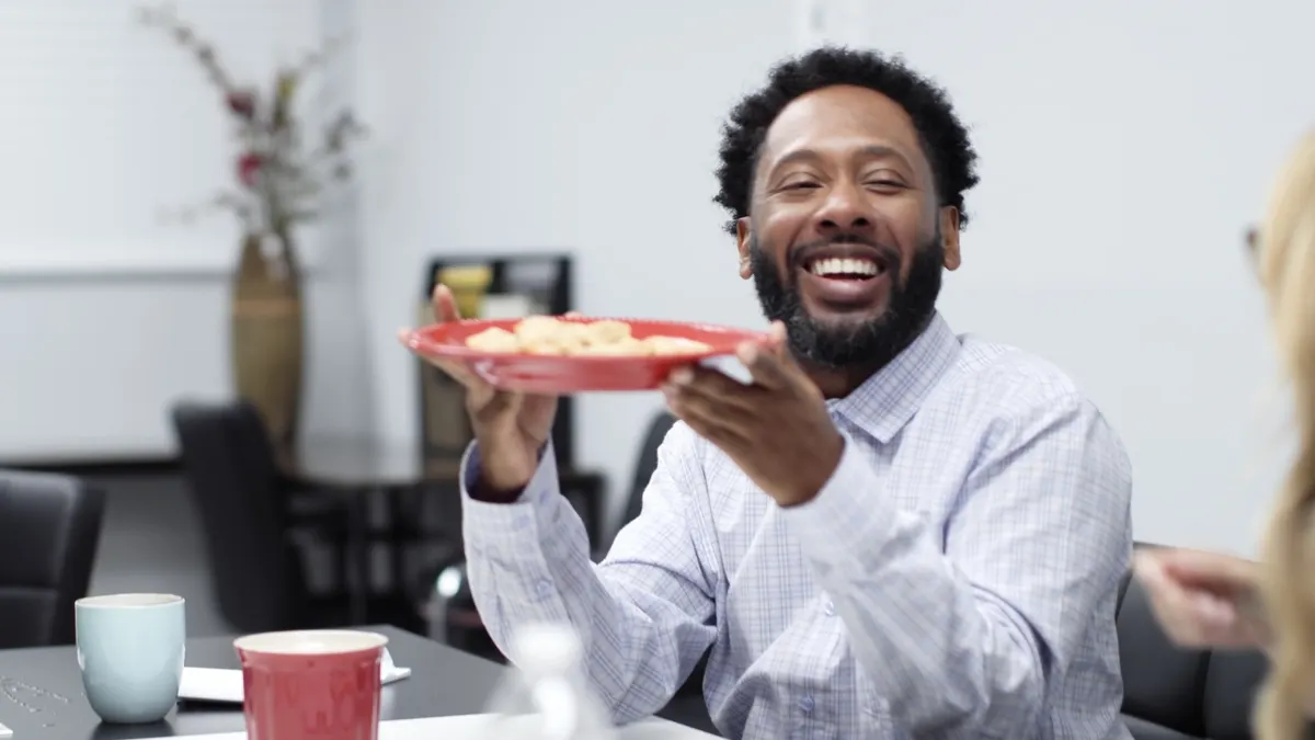 A man holds a plate of Totino's pizza rolls