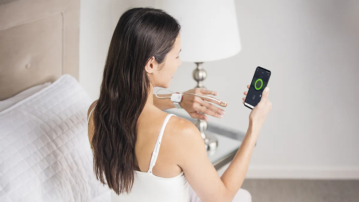 a woman using the opioid safety device built by Masimo