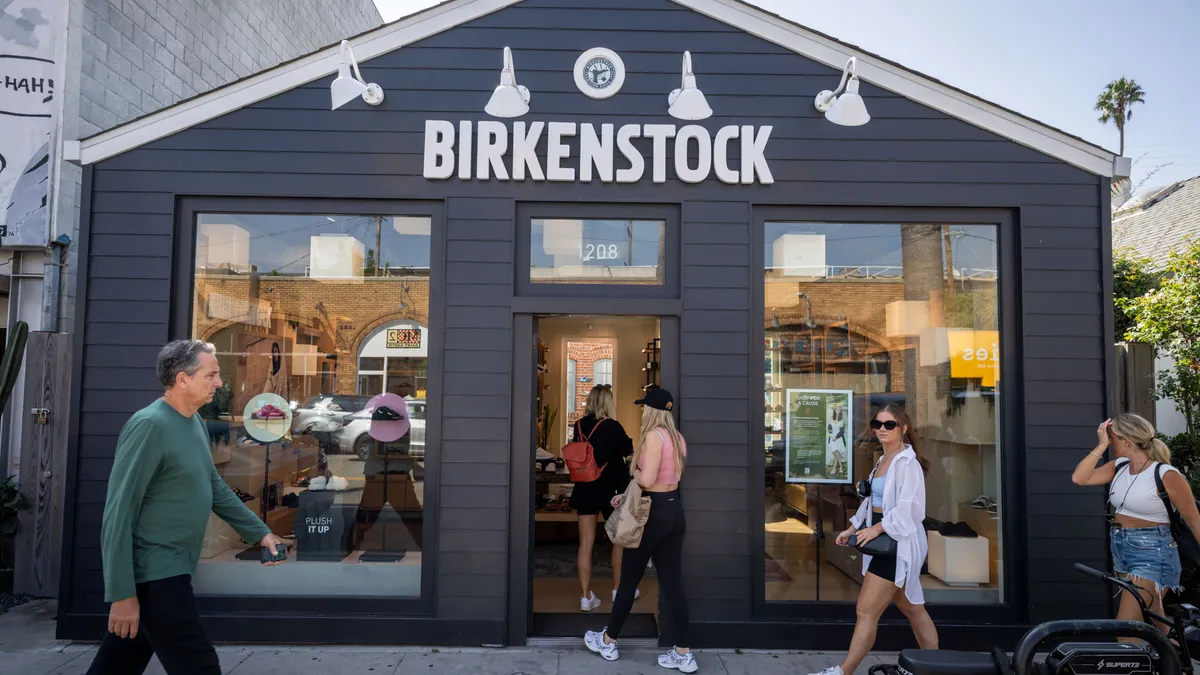 Pedestrians enter a storefront.