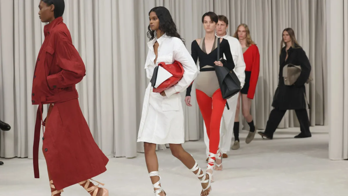 Models walk the runway against a white backdrop.