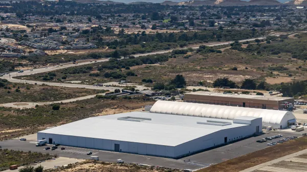 A large white building and a white hangar next to it