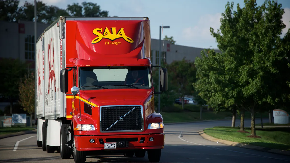 A Saia LTL truck drivin on a road.