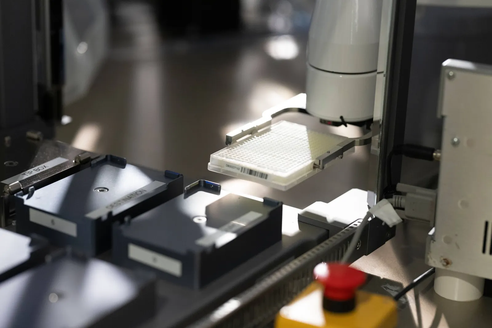 An automated machine moves a well plate in a laboratory.