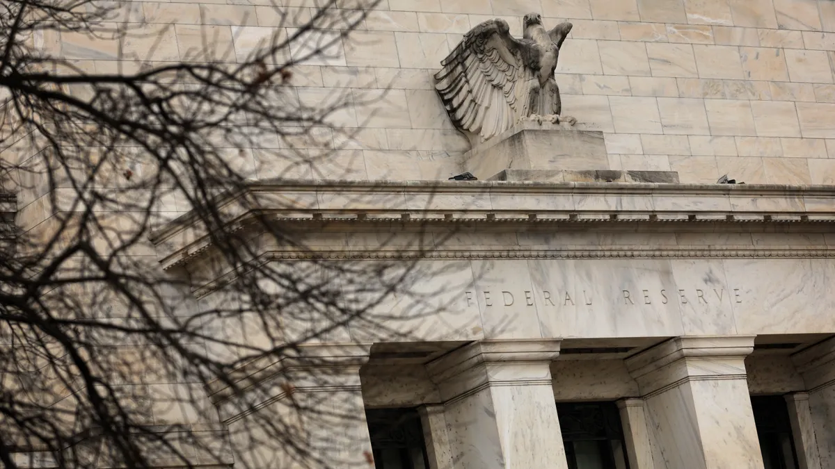 Exterior shot of federal building with eagle statue, tree branches