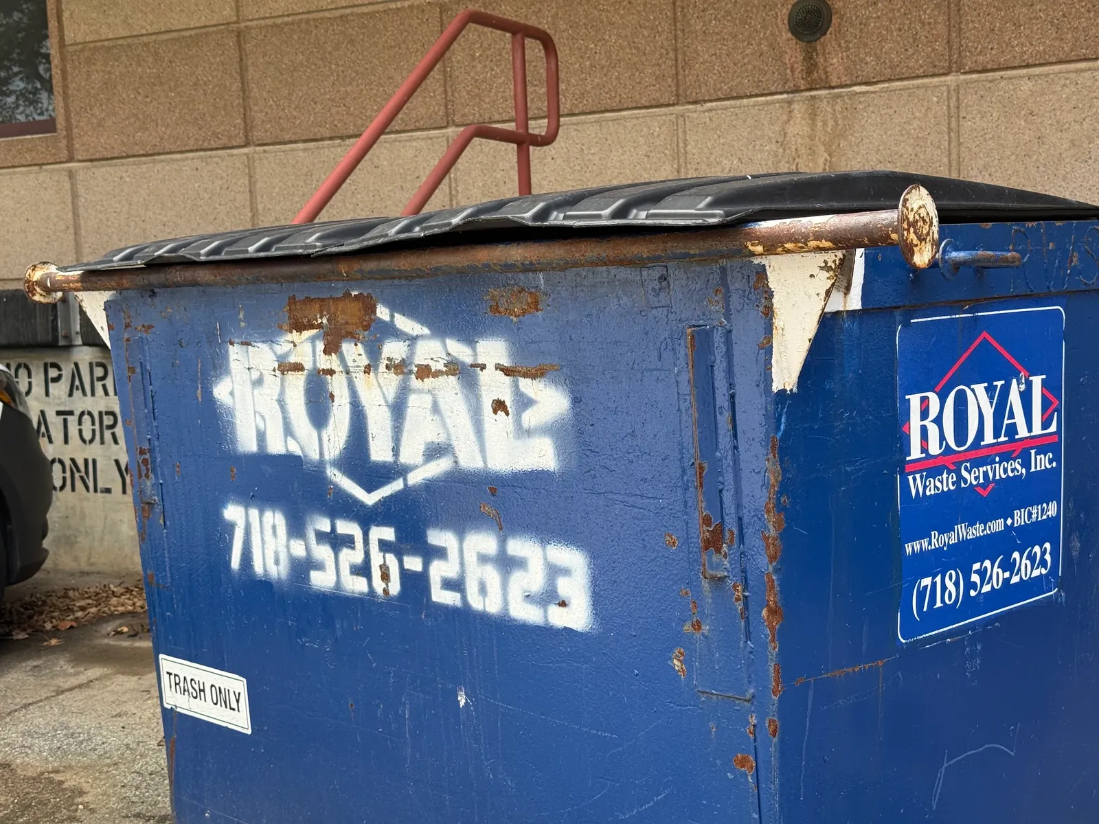 A dumpster with a Royal Waste Services decal