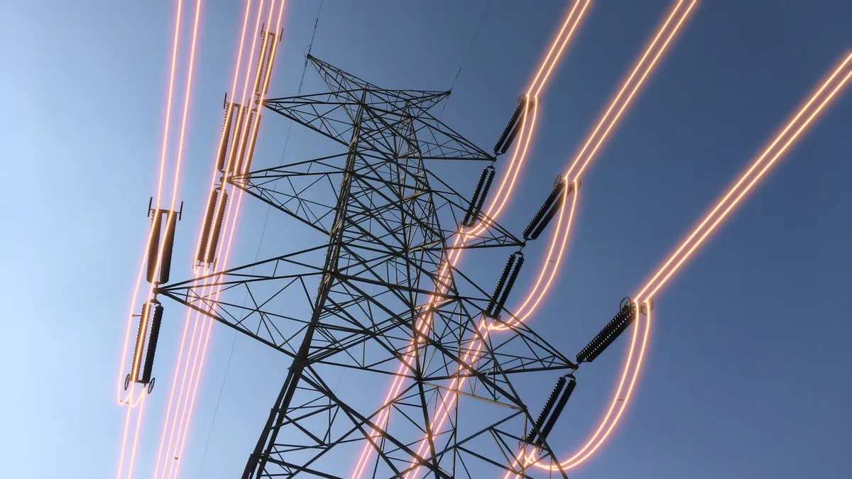 Electricity transmission towers with glowing wires.