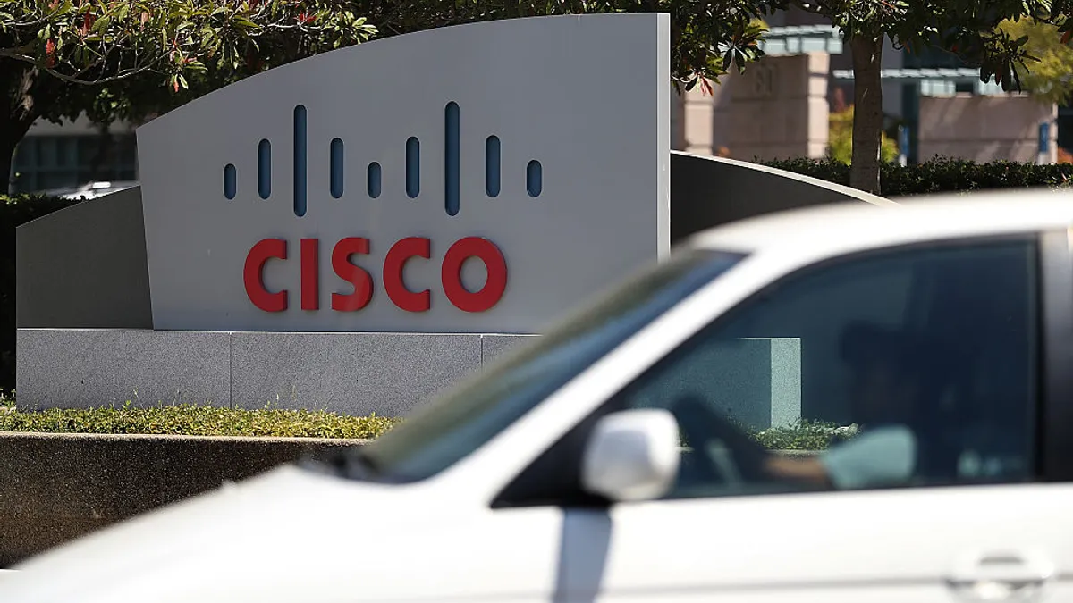 A sign reads Cisco in bright red letters outside a corporate office.