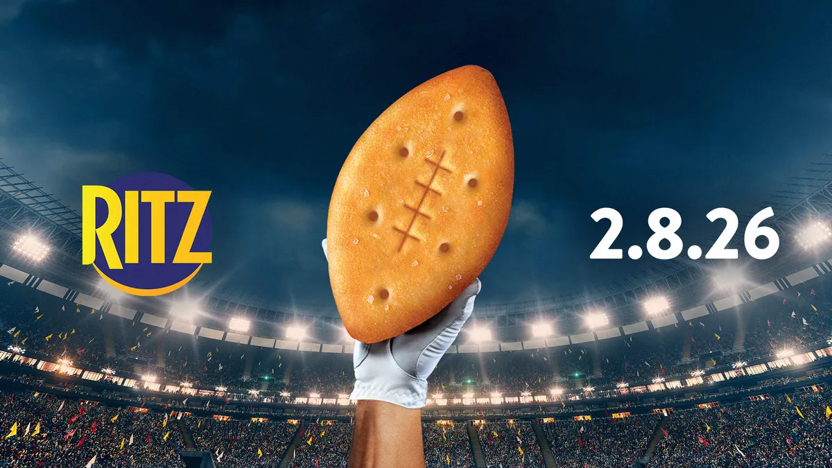 Ritz' campaign imagery for the 2026 Super Bowl featuring an athlete's hand as they hold up a football-shaped Ritz cracker.