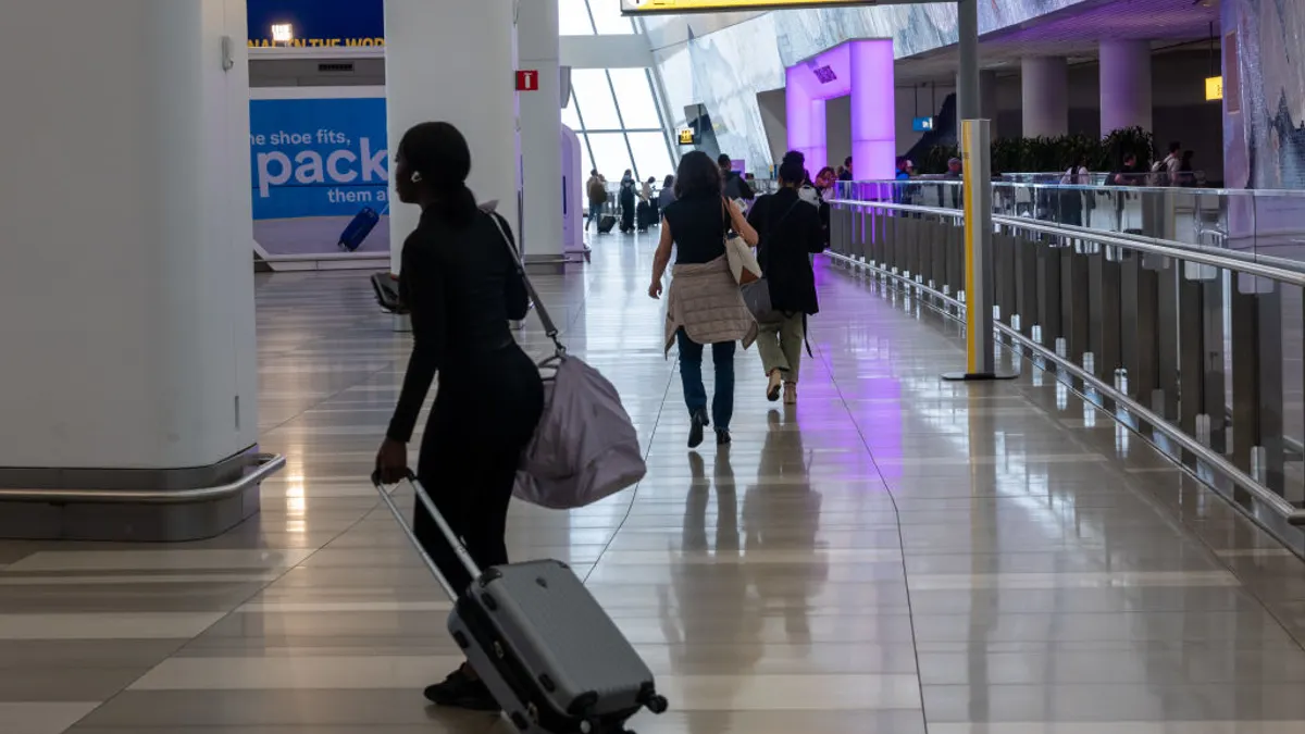 A traveler pulls a suitcase through an Amtrak terminal.