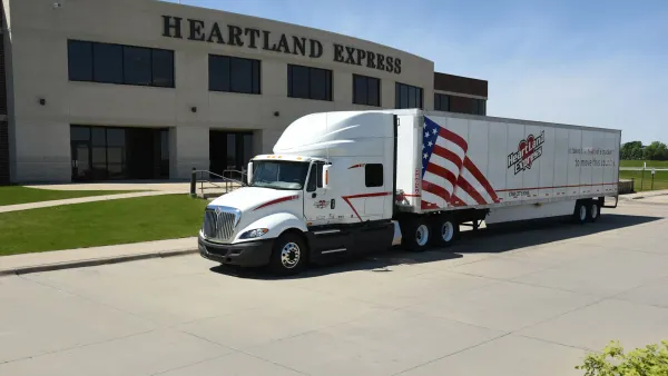 A freight truck parked in front of an office building.