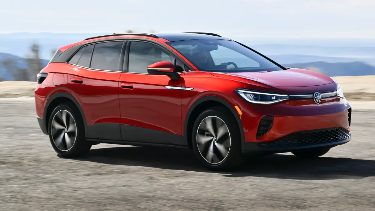 A red 2024 Volkswagen ID.4 electric SUV driving on a road.