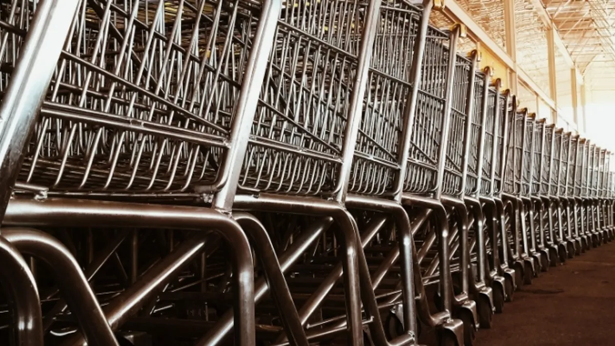 Metallic shopping carts aligned next to the wall inside a building