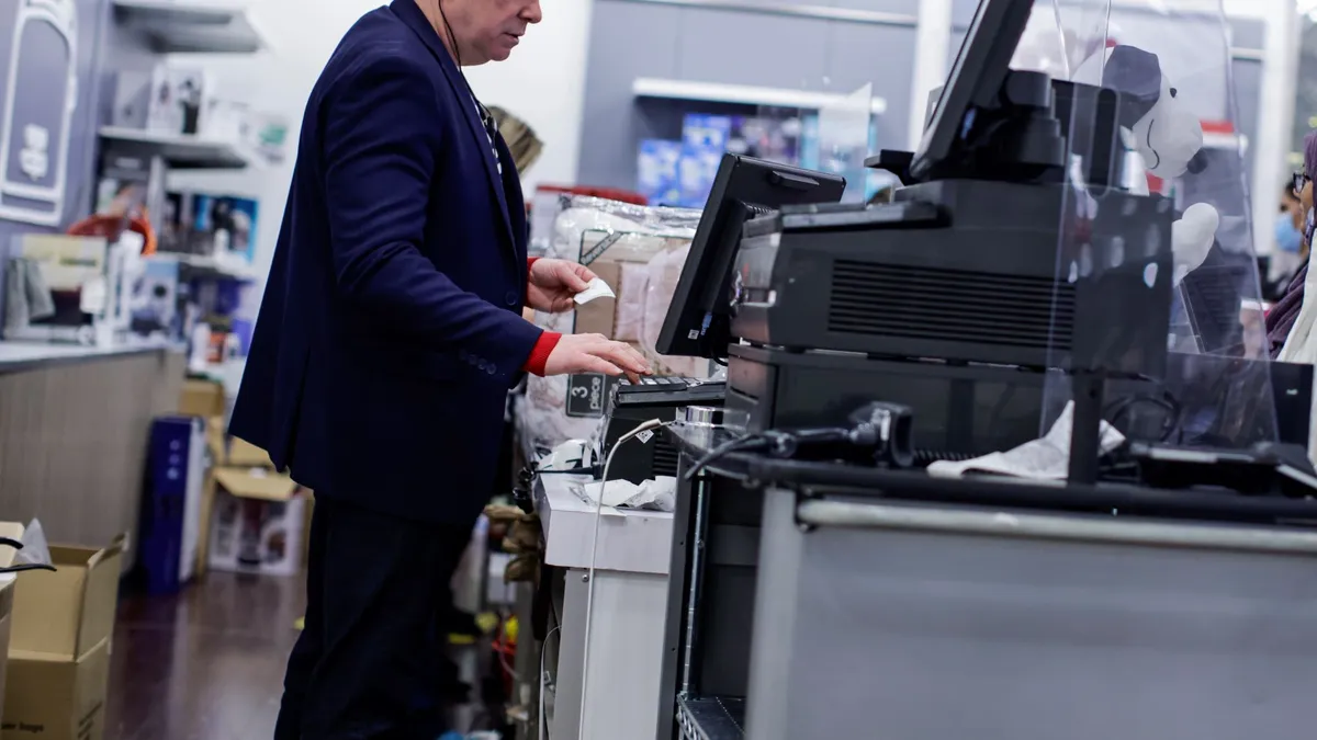 An employee uses a cash register.