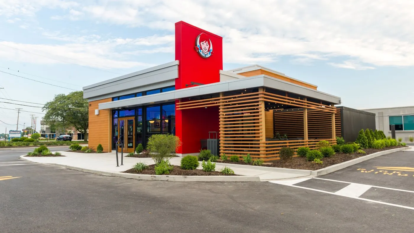 An image ofa brick colored building with a logl of a red-headed girl with pigtails.