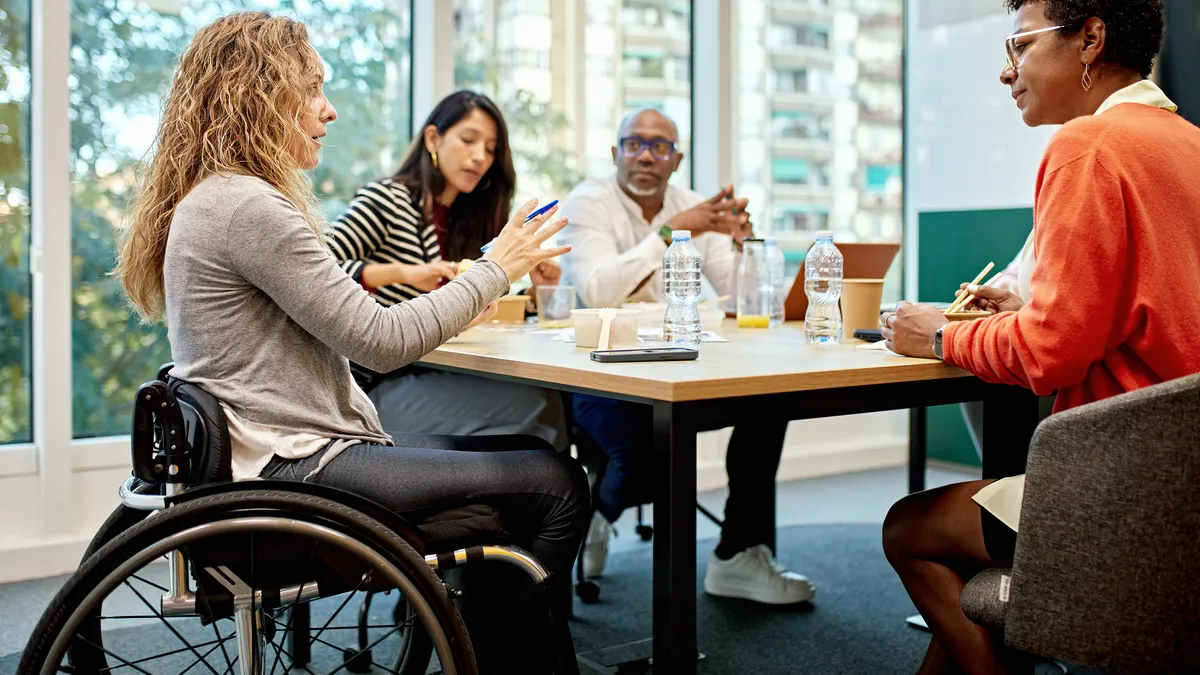 Diverse group of professionals, in discussion, sitting around conference table.