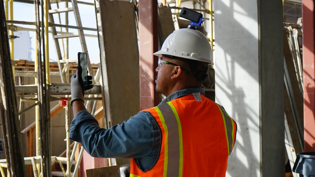 A worker with a camera mounted to their hardhat looks around a jobsite.